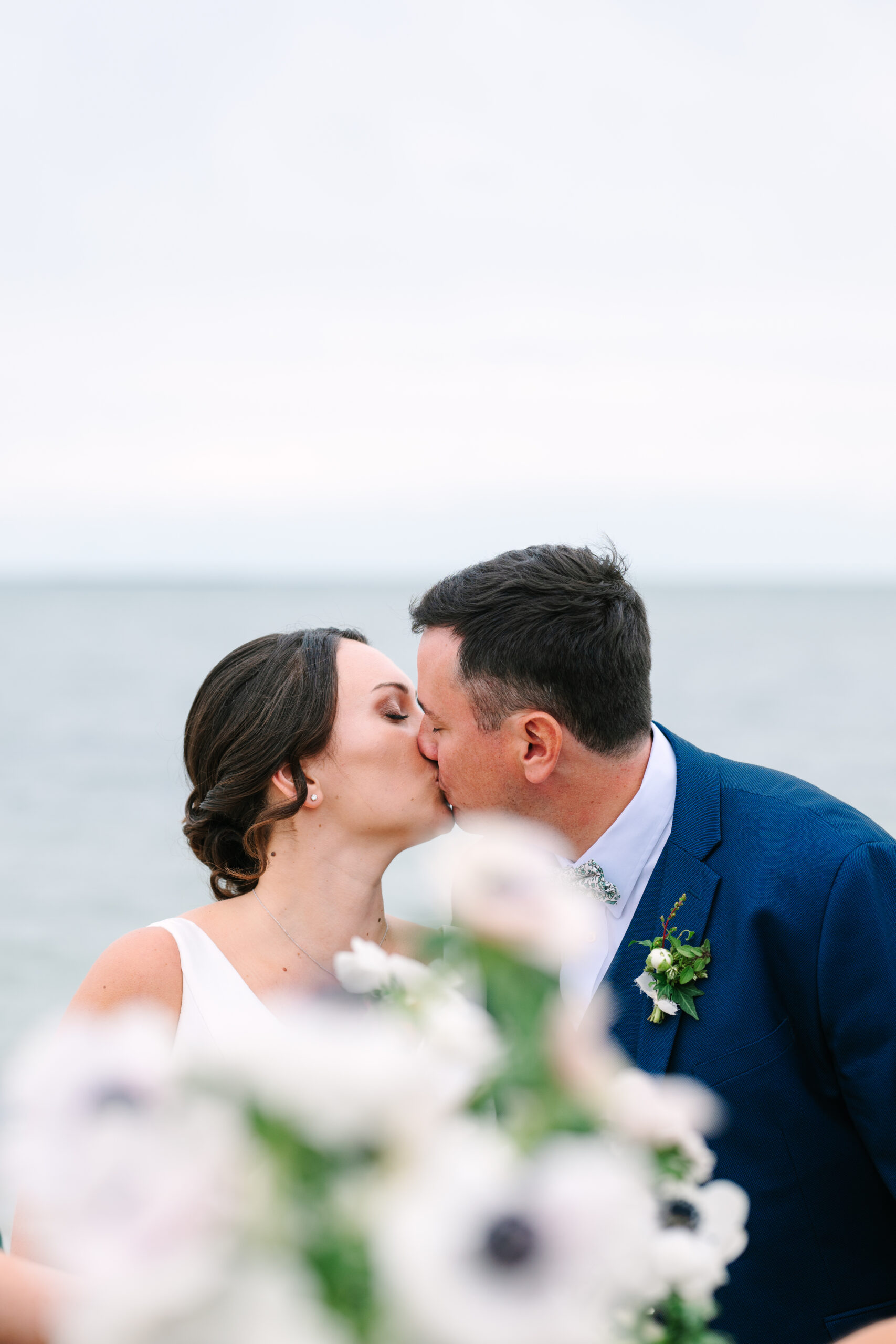 Bride and groom kissing on the beach in cape cod on their wedding day